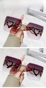 Détail de lunettes de soleil carrées sans monture dégradé gris-rose avec décor cœur