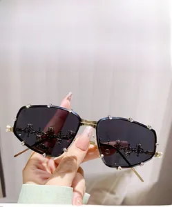 Detail view of oversized grey polygonal sunglasses with rhinestone-encrusted gold frames
