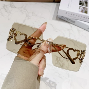 Lunettes de soleil carrées sans monture avec verres dégradés et branches cœur dorées