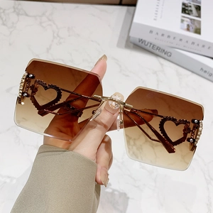 Lunettes de soleil carrées sans monture avec verres dégradés marron et détails cœur dorés