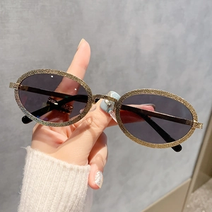 Lunettes de soleil ovales rétro avec monture métallique dorée texturée et verres gris foncé