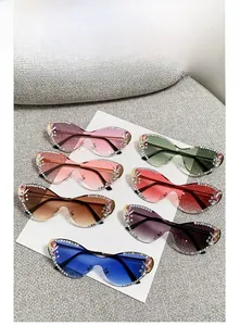 Détail de lunettes papillon sans monture ornées de strass et de pierres précieuses