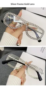 Dettaglio degli occhiali quadrati in metallo argento con intarsio di strass brillanti
