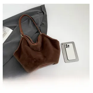 Detail of plush faux fur shoulder bag with brown leather handles in a chic layout