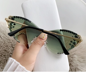 Détail de lunettes œil-de-chat à dégradé vert avec strass et branches en métal doré