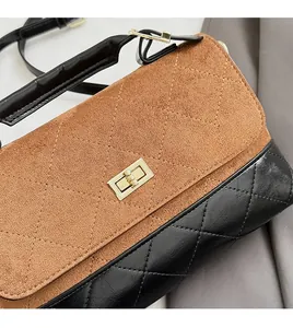 Détail du sac à bandoulière avec rabat en daim marron et cuir matelassé noir chic