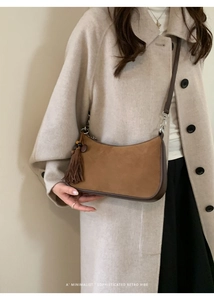 Detail of retro brown suede handbag with leather tassels and beaded charms decoration