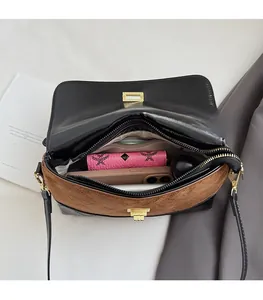Vue intérieure montrant les compartiments spacieux et le rangement du sac en cuir bicolore