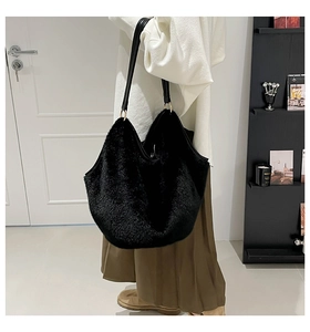 Close-up of black faux fur tote bag with leather strap and golden metal ring detail
