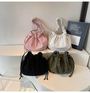 Detail von vier Cord-Kordelzugtaschen in Rosa, Weiß, Schwarz und Grün im Display