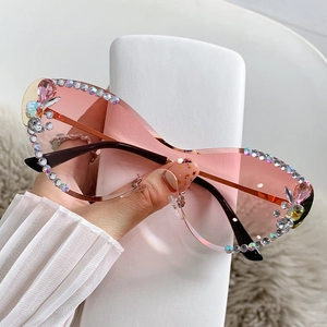 Lunettes de soleil œil de chat sans monture avec verres roses et détails en strass