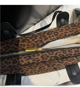 Vue détaillée du zip doré lisse et du motif léopard sur un sac fourre-tout chic