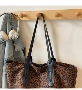 Détail du sac cabas léopard avec anses renforcées en cuir sur crochet en bois