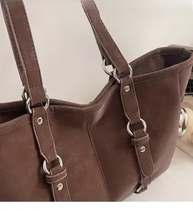 Detailed close-up of dark brown vintage tote bag with rivets and metal ring hardware