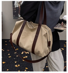 Detalle de bolso tote de lona beige con asas de cuero y bolsillo lateral funcional