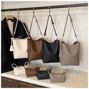Detail of lychee pattern leather bucket bag and mini pouch with adjustable strap and metal hooks