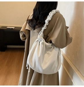 Detail der cremeweißen Cord-Hobo-Tasche mit breitem Plissee-Schultergurt im Freizeit-Look