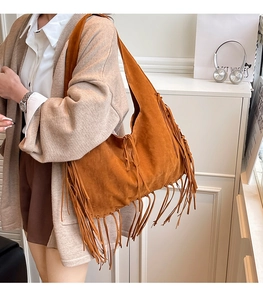 Detailed view of bohemian brown suede tote bag featuring long fringes and shoulder strap