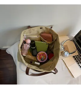 Interior view of beige canvas tote bag with brown leather handles showing large capacity