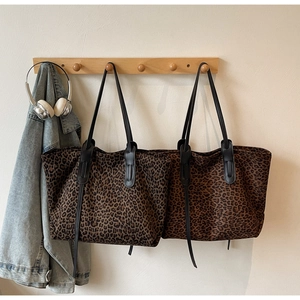 Vue détaillée de sacs cabas à imprimé léopard en deux couleurs sur un crochet