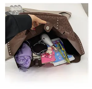 Interior view showing large capacity of leopard tote bag with studs and daily items