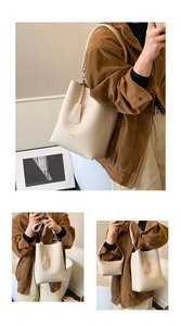 Detail view of large cream leather tote bag with pebble texture and adjustable shoulder strap