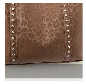 Detailed view of leopard print fabric with decorative metal rivets on the tote bag