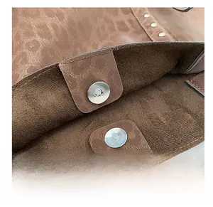 Detail of silver magnetic snaps and leopard print fabric on a vintage tote bag