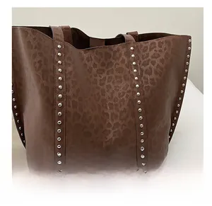 Close-up of leopard print tote bag with metallic stud details and premium stitching