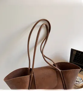 Close-up of durable brown leather tote handles with high-quality stitching detail