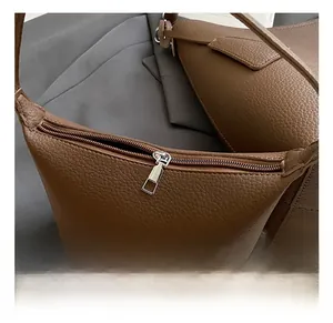 Close-up of premium brown pebble grain leather and durable silver metal zipper details