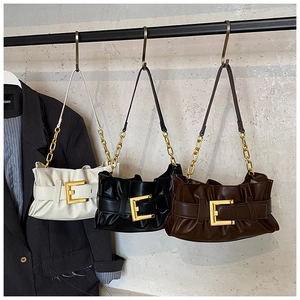 Close-up of pleated shoulder bags in white, black, and brown with gold buckles