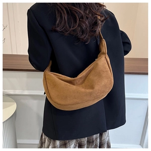 Gedetailleerde close-up van bruine suède hobo tas met focus op de zachte textuur en vorm