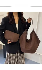 Detail of a large brown suede tote bag and matching zippered pouch for daily use