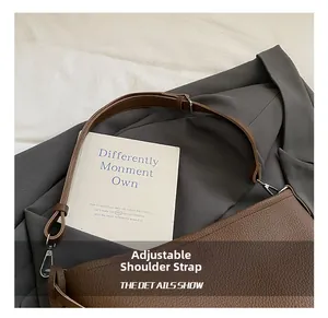 Detail of adjustable silver buckle on a vintage dark brown lychee leather shoulder bag