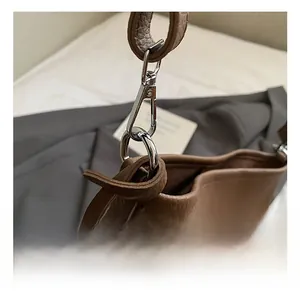 Macro detail of high-quality silver metal clasp and lychee pattern brown leather texture