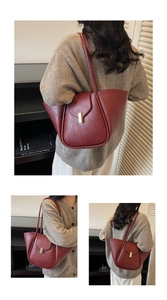Macro detail of dark red shell-shaped tote bag with golden buckle and retro leather texture