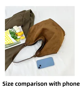 Brown suede tote bag size comparison with a smartphone and autumn blazer on white linen