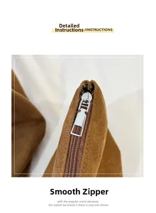 Detail view of smooth silver metal zipper on premium brown suede tote bag