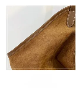 Close-up of high-quality stitching and suede texture on large brown tote bag