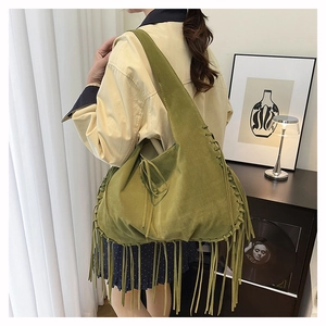 Detailed view of the woven seams and long suede fringe on this avocado green hobo bag