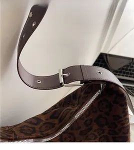 Detail of adjustable wide shoulder strap with silver buckle on leopard print tote bag