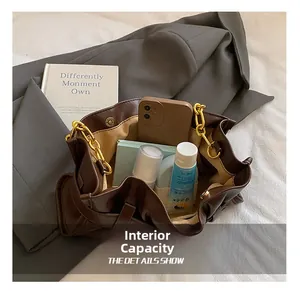 Spacious interior of dark brown soft leather tote bag with gold chain and everyday items