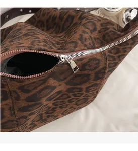 Close-up of the smooth silver metal zipper on the leopard print suede shoulder bag