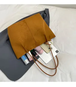 Top view of a large brown suede tote bag showing spacious interior with daily essentials