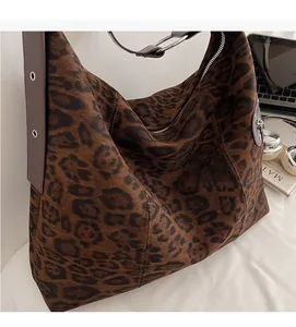 Macro view of leopard print hobo bag showing soft suede texture and brown leather strap