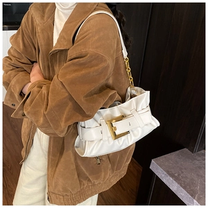 Detail of off-white pleated underarm bag with gold buckle and chain strap