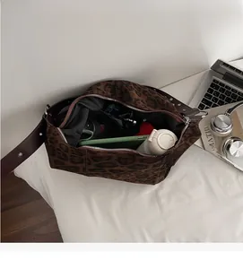 Interior view showing large capacity of the leopard print suede bag with daily essentials