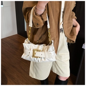 Detail of white pleated cloud bag with metallic chain and large gold buckle on strap