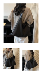 Detail of black suede hobo bag featuring wide strap with silver eyelets and side zip pocket